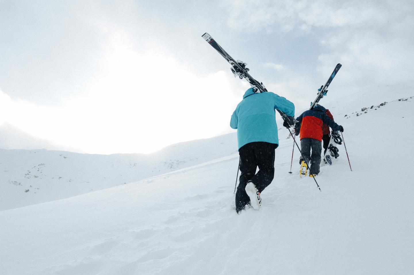 Skiers walking up a mountain