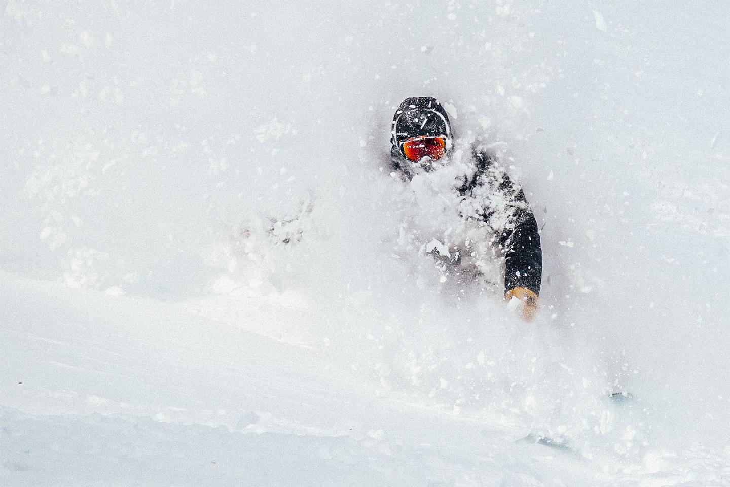 A person snowboarding through powder