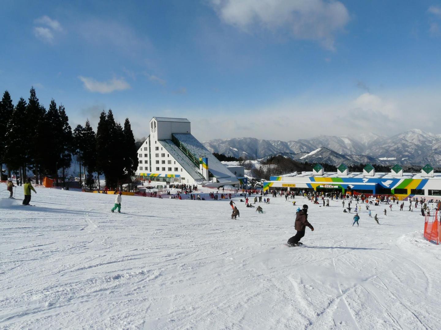 Snowboarder in front of facility at Washigatake Ski Resort logo
