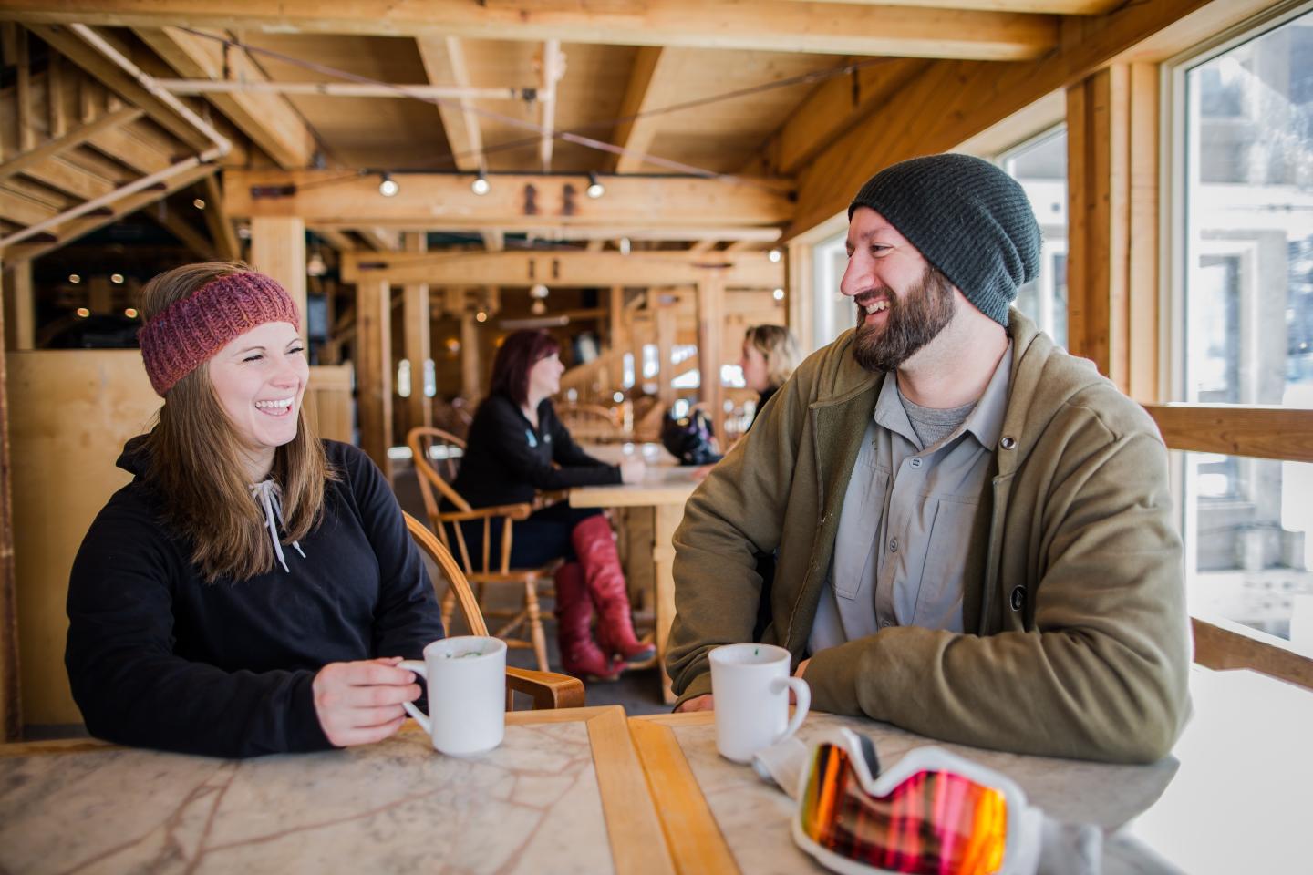 two people, sitting at a table, smiling