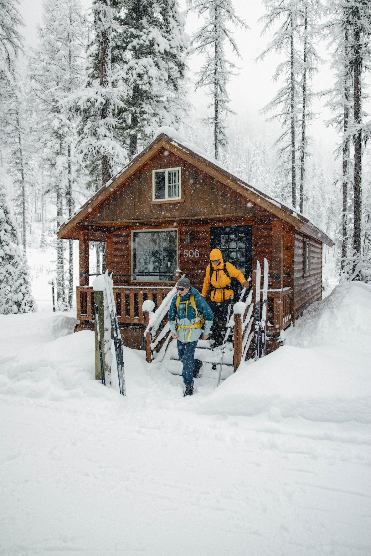 skiers walking out of a cabin