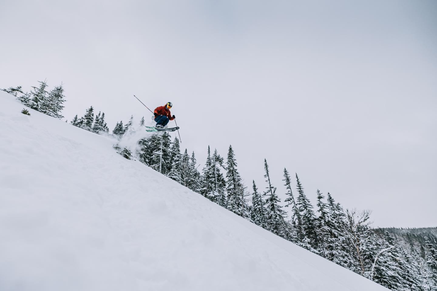skier in the air, going down mountain