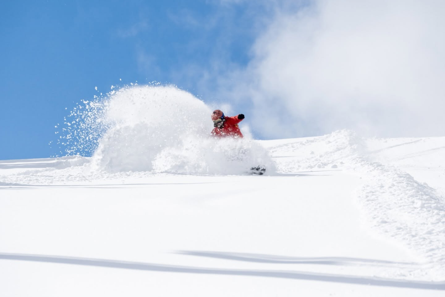 snowboarder riding in powder at showdown montana