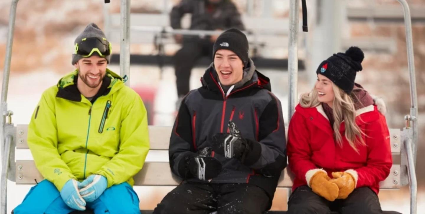 three people laughing on the chairlift at Frost Fire park