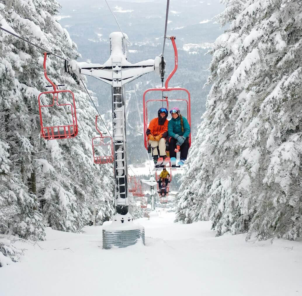 Skiers on a chairlift at Magic Mountain Vermont