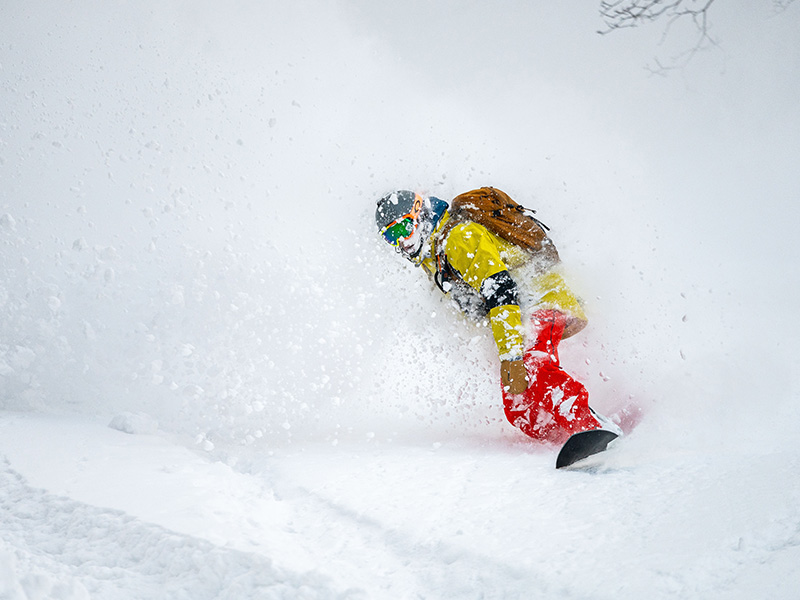 Snowboarder riding deep powder in Japan