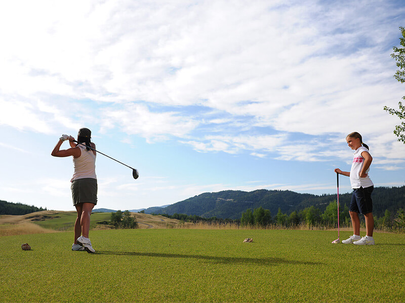A woman and her daughter golfing Silver Mountain Resort.